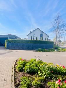 a garden with flowers in front of a white house at Ruhige Ferienwohnung in Appenweier