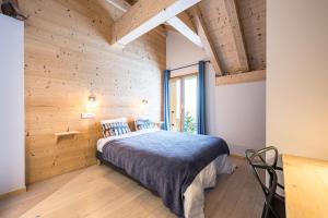 a bedroom with a bed and a wooden wall at Germain Ski Lodge in La Toussuire