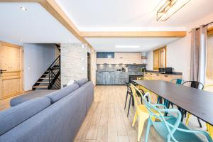 a living room with a couch and a table and chairs at Germain Ski Lodge in La Toussuire