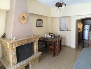 a living room with a fireplace and a dining table at Emma's studio house by Kapsali beach in Kapsali +18 photos