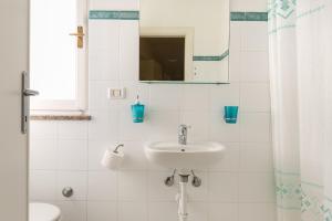 a white bathroom with a sink and a mirror at Monolocale casa Lucia in Campo nell'Elba