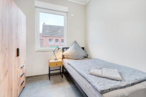 a small bedroom with a bed and a window at Stadtquartier Ahaus in Ahaus