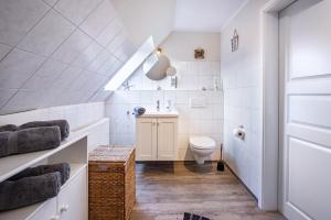 a white bathroom with a toilet and a sink at Ferienwohnung Lemburg in Nindorf +18 photos