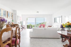 a white living room with a white couch and a table at Casa Fuente del Sol in Conil de la Frontera
