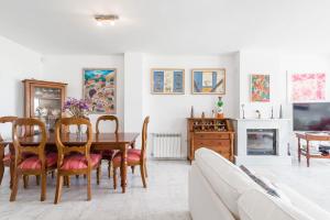 a dining room with a table and chairs and a tv at Casa Fuente del Sol in Conil de la Frontera