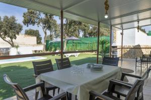 a dining room with a table and chairs and a pool at El encanto de Ronda in Ronda