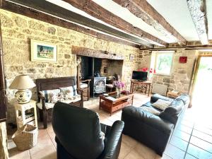 a living room with couches and a stone fireplace at Gite rural La Madeleine in Saint-Mathurin-Léobazel