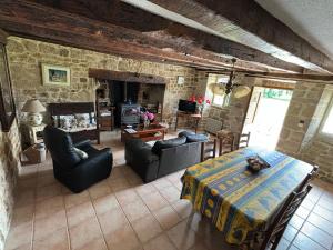 a living room with a table and chairs and a fireplace at Gite rural La Madeleine in Saint-Mathurin-Léobazel