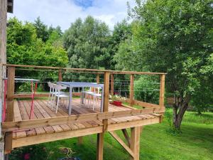 a wooden deck with a table and chairs on it at Charming Gîte Le 1681 Xl in Girancourt +4 photos