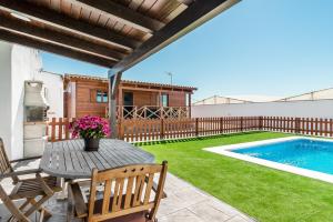 a patio with a table and chairs and a swimming pool at Casa Hefestión in Conil de la Frontera