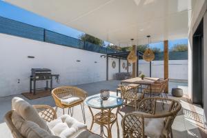 a patio with chairs and a table and a grill at Tu Paraíso Privado Con Piscina in Albolote