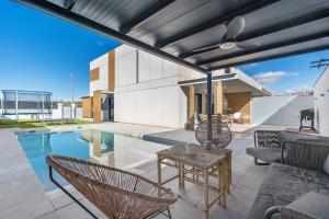 a patio with a pool and chairs and a table at Tu Paraíso Privado Con Piscina in Albolote
