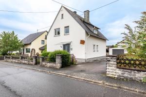 a white house with a black roof at Ferienhaus Soonwald Liebe in Seesbach