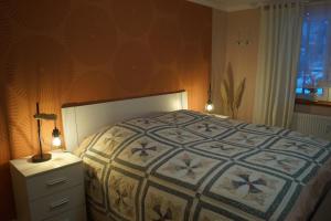 a bedroom with a bed and a dresser with a lamp at Schmidnickels Hof in Schwarzerden