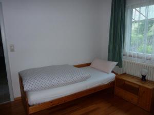 a small bed in a room with a window at Ferienwohnung am Wald Schuttertal in Schuttertal +3 photos