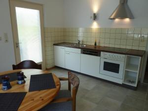 a kitchen with a table and a white stove top oven at Ferienwohnung am Wald Schuttertal in Schuttertal