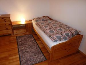 a bedroom with a bed and a dresser with a lamp at Ferienwohnung am Wald Schuttertal in Schuttertal