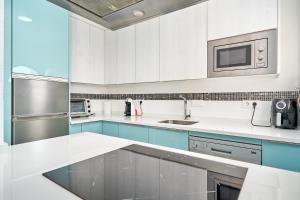 a kitchen with white counters and blue cabinets at Atalaya in Almuñécar