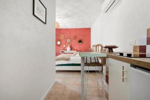 a kitchen and bedroom with a bed and a table at Les Gîtes W elles come in Cotignac