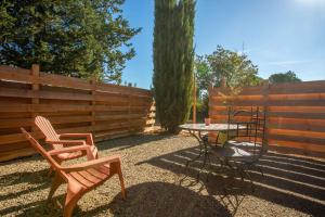 a patio with a table and chairs and a fence at Les Gîtes W elles come in Cotignac