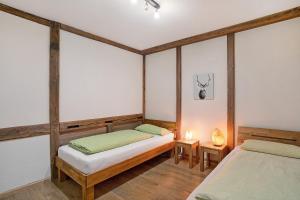 two twin beds in a room with wooden beams at Schwarzwald-Lodge - hundefreundlich in Kappelrodeck