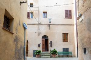 an alley with a green bench in front of a building at Finestra dell'Angelo a Pienza in Pienza