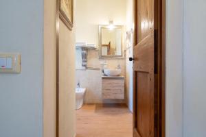 a bathroom with a sink and a toilet and a mirror at Finestra dell'Angelo a Pienza in Pienza +26 photos
