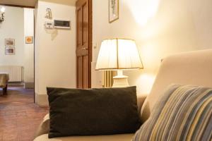 a lamp sitting next to a couch with a pillow at Finestra dell'Angelo a Pienza in Pienza