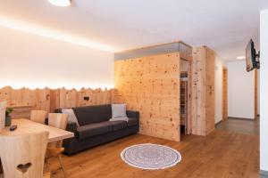 a living room with a couch and a wooden wall at Huberhof Gais in Gais