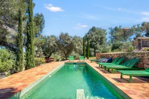 a swimming pool with green lounge chairs and a pool at Toscana in Benissa