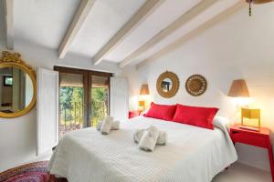 a bedroom with a large white bed with red pillows at Toscana in Benissa +21 photos