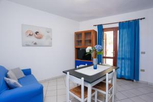 a living room with a blue couch and a table at mirtagru appartamento dell'oleandro in Budoni