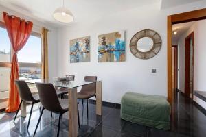 a dining room with a table and chairs and a mirror at Marfolin 22 in El Cotillo