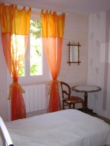 a bedroom with a bed and a table and a window at Gîte Ancien Relais De Poste in Les Rousses
