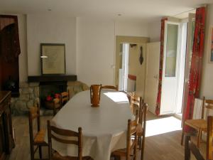 a dining room with a table and chairs and a fireplace at Gîte Ancien Relais De Poste in Les Rousses