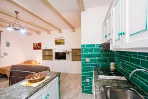 a kitchen with green tiles on the walls at mirtagru Bilo Mare 2 in Budoni +13 photos