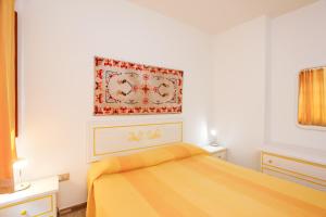 a bedroom with a bed with a yellow blanket at mirtagru Bilo Mare 2 in Budoni