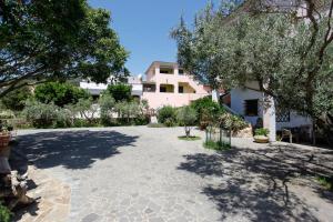 a large courtyard with trees and a building at mirtagru Bilo Mare 2 in Budoni
