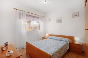 a bedroom with a bed and a table and a window at Las Arenas Medio in La Mareta