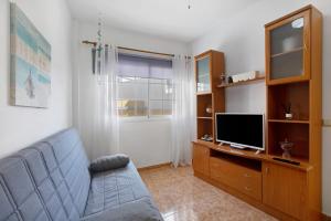 a living room with a couch and a tv at Las Arenas Medio in La Mareta