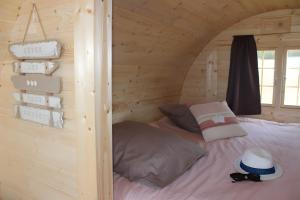 a bed in a log cabin with a window at Barrel Papilles En Escapade in Sevremont
