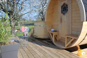 a large wooden sauna with a table on a wooden deck at Barrel Papilles En Escapade in Sevremont