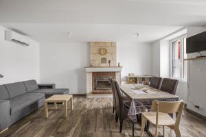 a living room with a couch and a table and a fireplace at Gîte Brain de nuit in Brain-sur-Allonnes