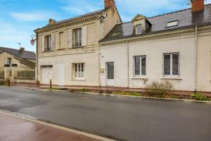 an old white building on the side of a street at Gîte Brain de nuit in Brain-sur-Allonnes