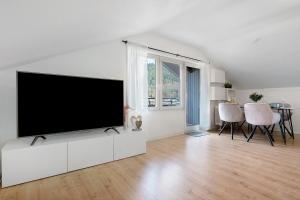 a white living room with a flat screen tv at Ferienwohnung Kraft in Bad Wildbad
