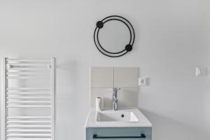 a bathroom with a sink and a mirror on the wall at Gîte Brain de nuit in Brain-sur-Allonnes