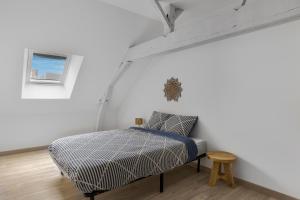 a bedroom with a bed in a white wall at Gîte Brain de nuit in Brain-sur-Allonnes