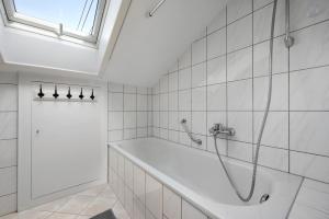 a white bathroom with a shower and a tub at Ferienwohnung Kraft in Bad Wildbad +28 photos