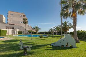 a park with dinosaur sculptures in the grass at Apartamento Clayma in Puerto de Mazarrón