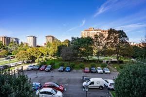 a parking lot with parked cars in a city at Rincón De Julia in Gijón